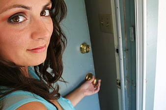 Close-up portrait of woman opening blue door