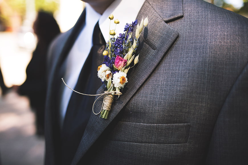 Close-up of groom's boutonniere on grey suit