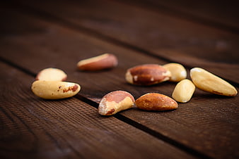 Scattered Brazil Nuts on Dark Wooden Table