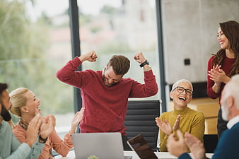 Diverse business team celebrating success in modern office meeting