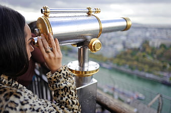 Woman in Leopard Coat Looking Through Binoculars at City View