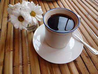 White Coffee Cup with Daisies on Bamboo Table