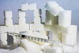 Insulin syringe on sugar cubes representing diabetes