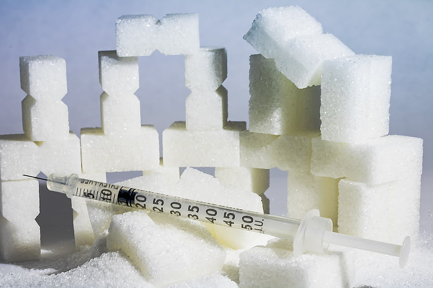 Insulin syringe on sugar cubes representing diabetes