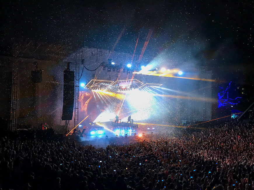 Live concert stage with bright lights and large crowd