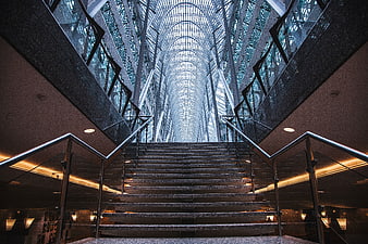 Modern glass atrium staircase with symmetrical architecture