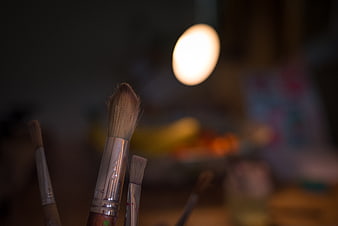Close-up of paintbrushes in an art studio with bokeh background