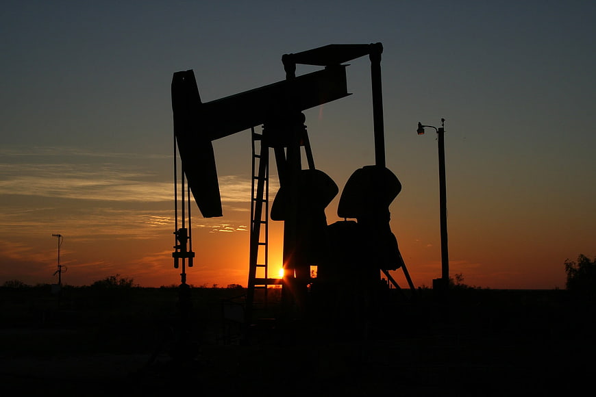 Silhouette of Oil Pump Jack Against Sunset Sky