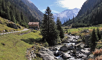 Alpine Mountain Landscape With Stream, Meadow, And Wooden Cabin