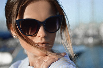 Woman in Sunglasses with Windblown Hair by the Sea