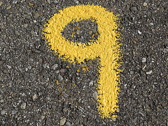 Worn yellow number nine painted on rough asphalt road surface