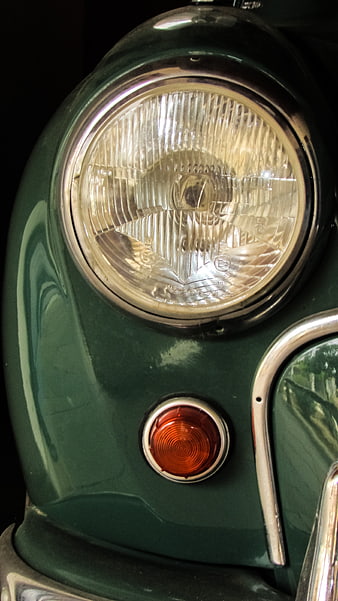 Close-up of vintage green car headlight and turn signal
