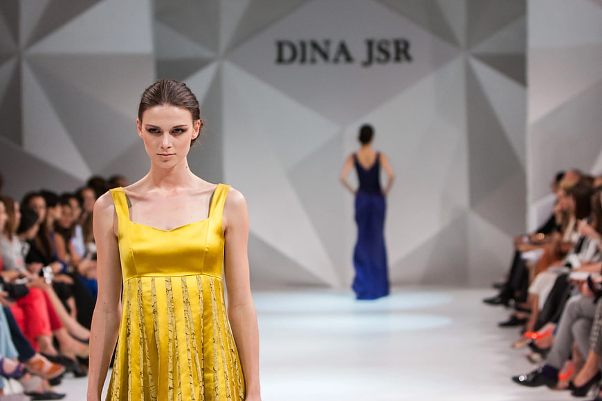 Fashion model in yellow dress walking runway