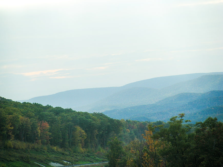 Serene Mountain Landscape with Forested Hills and Misty Sky