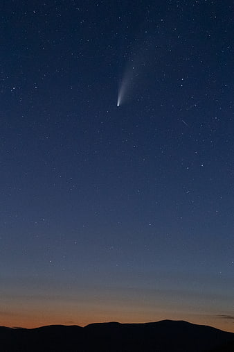 Comet in Starry Night Sky Over Mountain Silhouette