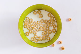 Top View of Cereal Rings in Green Bowl with Milk