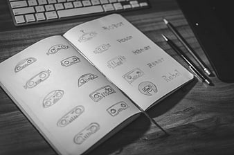 Hand-drawn robot logo sketches in notebook on desk