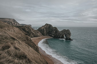 Dramatic coastal landscape with natural rock arch and sandy beach
