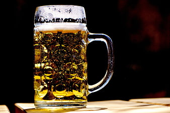 Chilled Beer Mug With Foam On Wooden Table Against Black Background