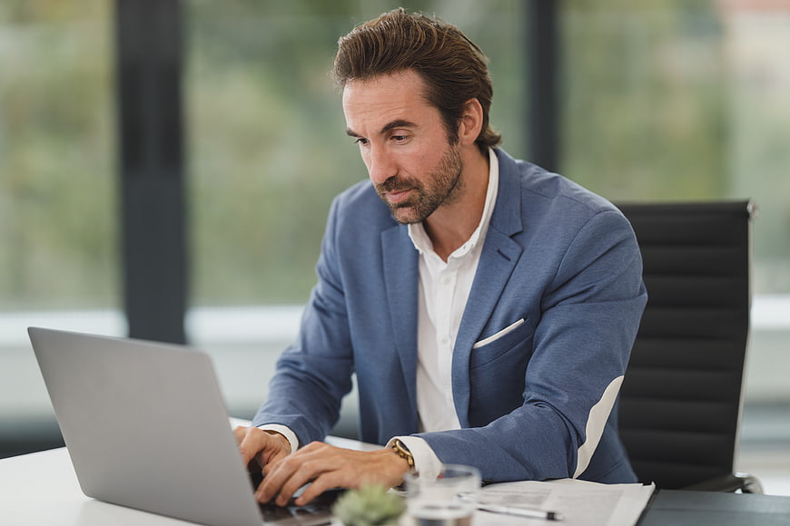 Professional businessman working on laptop in modern office