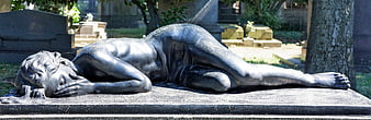 Bronze statue of reclining grieving woman in cemetery