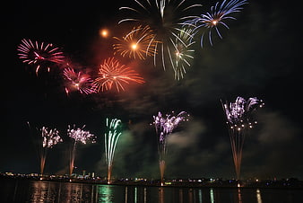 Colorful fireworks exploding over city skyline at night