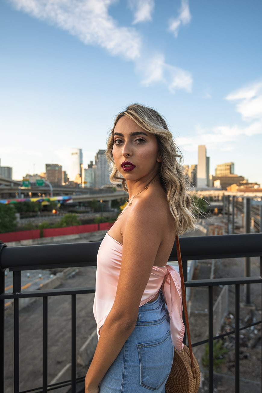 Stylish Blonde Woman in Pink Top on Urban Rooftop