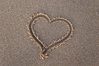 Heart drawn in sand on beach