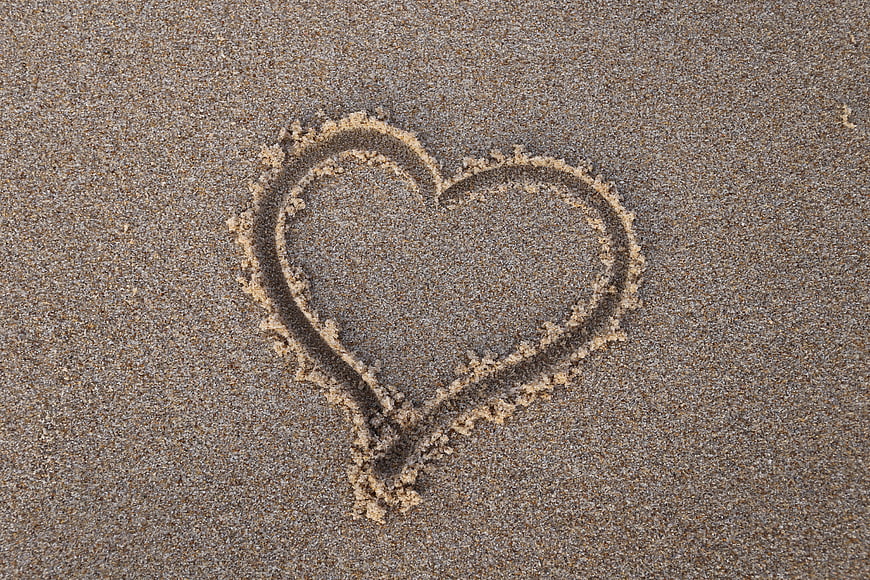 Heart drawn in sand on beach