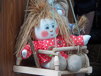 Handmade Straw Doll in Red Polka Dot Dress on Wooden Swing