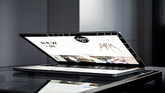 Laptop displaying online shopping website on glass desk
