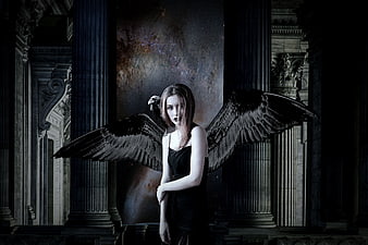 Gothic woman with black wings in dark fantasy ruins