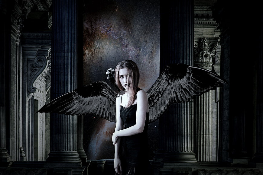 Gothic woman with black wings in dark fantasy ruins