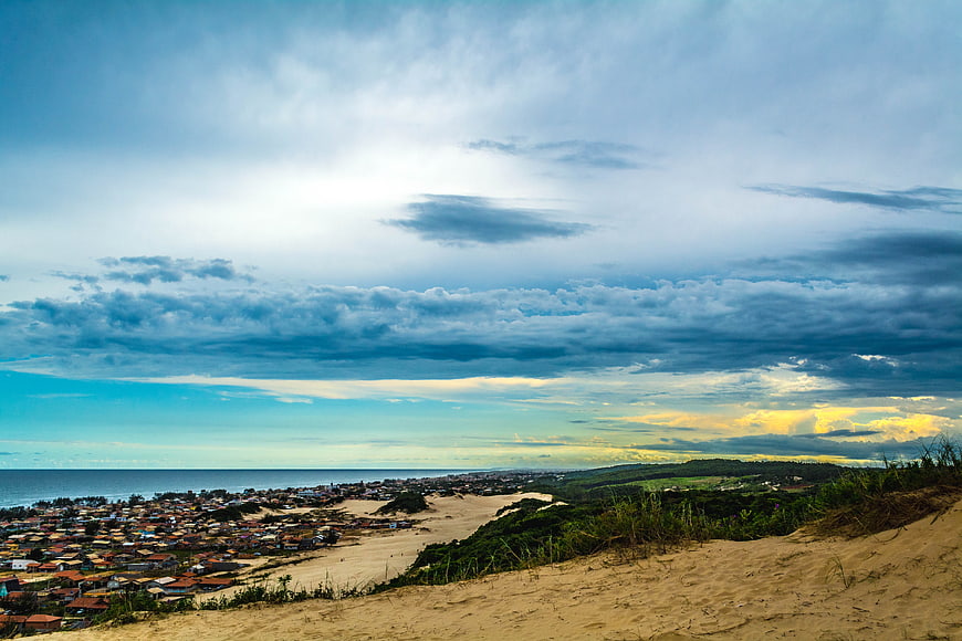 Dramatic coastal landscape with sand dunes and town