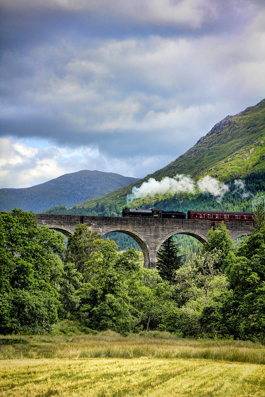 Steam train crossing Glenfinnan Viaduct in Scottish Highlands