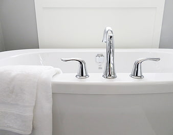 Modern White Bathtub with Chrome Faucet and Towel