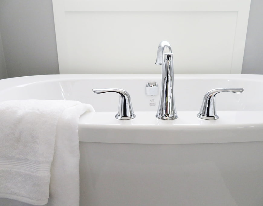 Modern White Bathtub with Chrome Faucet and Towel