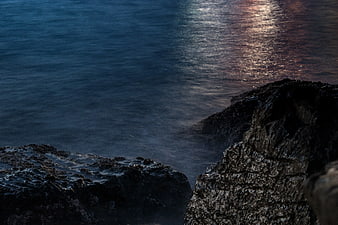 Dark Rocky Coastline with Misty Ocean at Dusk