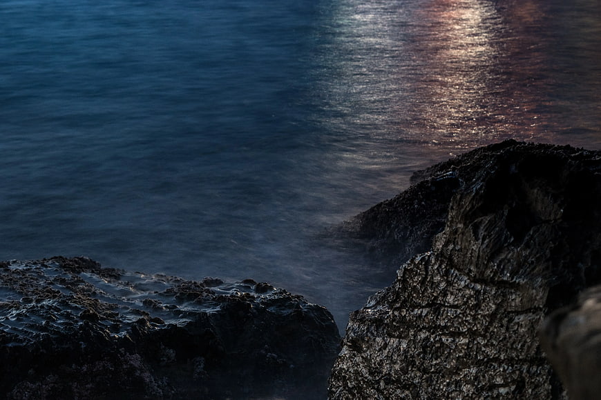 Dark Rocky Coastline with Misty Ocean at Dusk