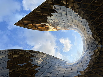 Low angle view of modern curved glass skyscraper architecture