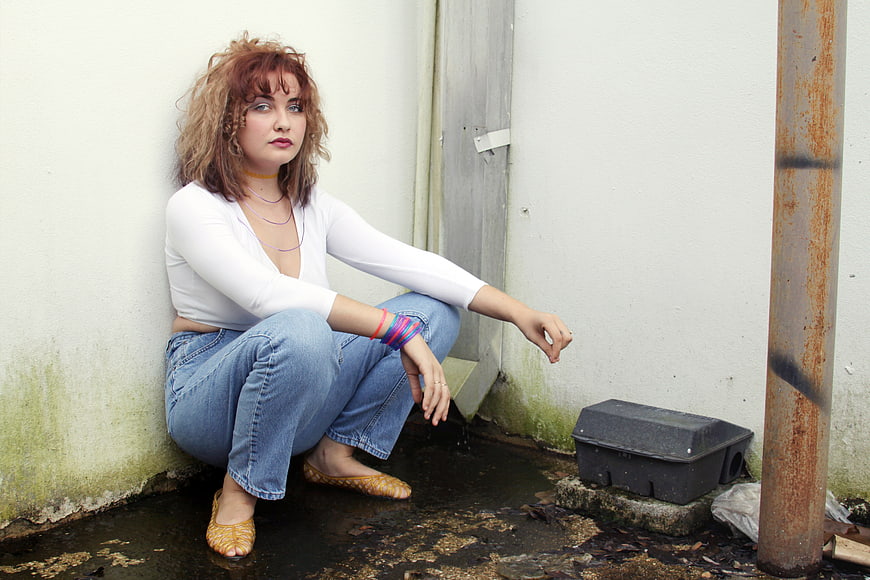 Moody portrait of woman sitting in urban alley