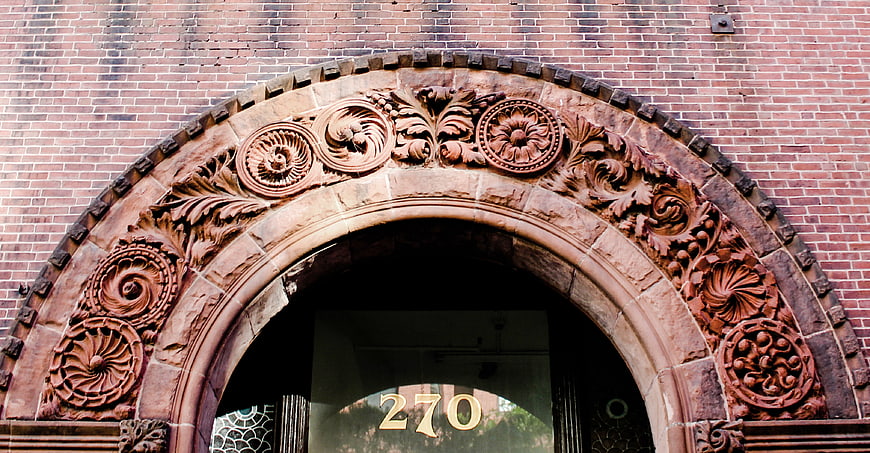 Ornate Sandstone Archway on Red Brick Building