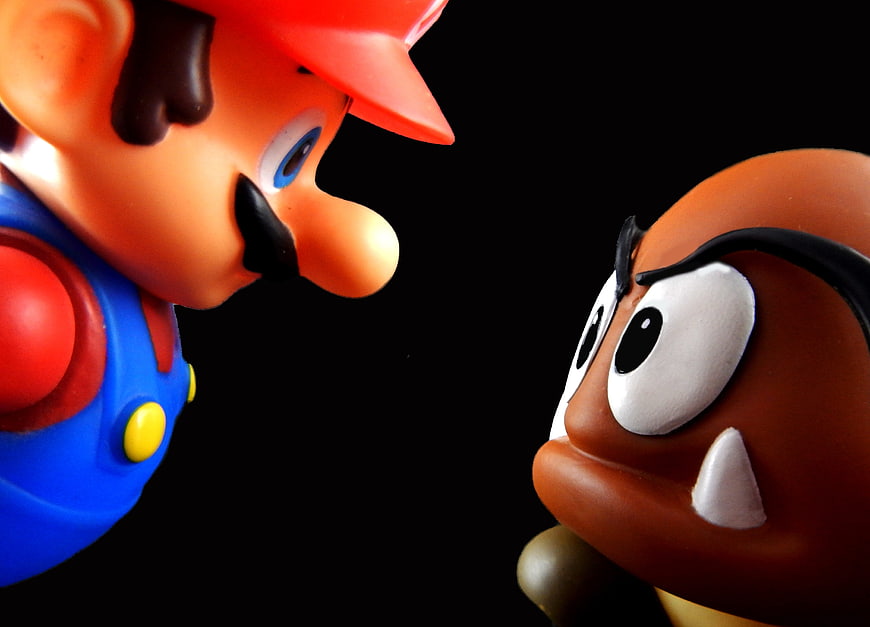 Close-up of Mario and Goomba figurines facing off