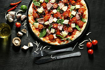 Uncooked Pizza with Fresh Ingredients on Dark Table