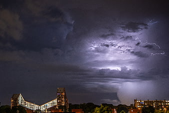 Dramatic Lightning Storm Over Modern City Skyline at Night