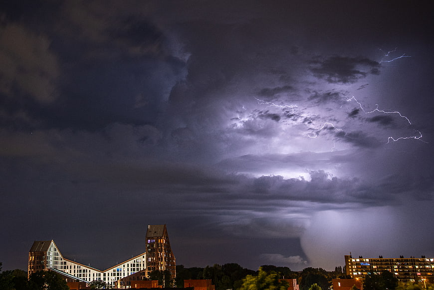 Dramatic Lightning Storm Over Modern City Skyline at Night