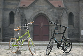 Two Folding Bicycles Parked on Cobblestones