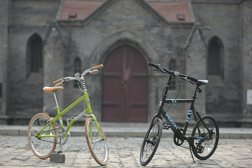 Two Folding Bicycles Parked on Cobblestones