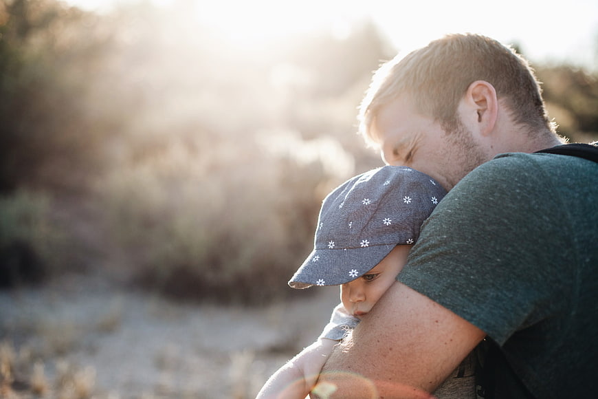 Father Hugging Toddler In Golden Hour Light