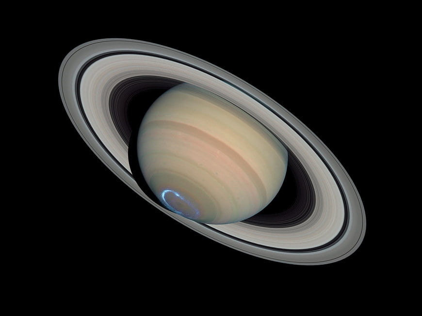 Saturn with rings and aurora borealis in space